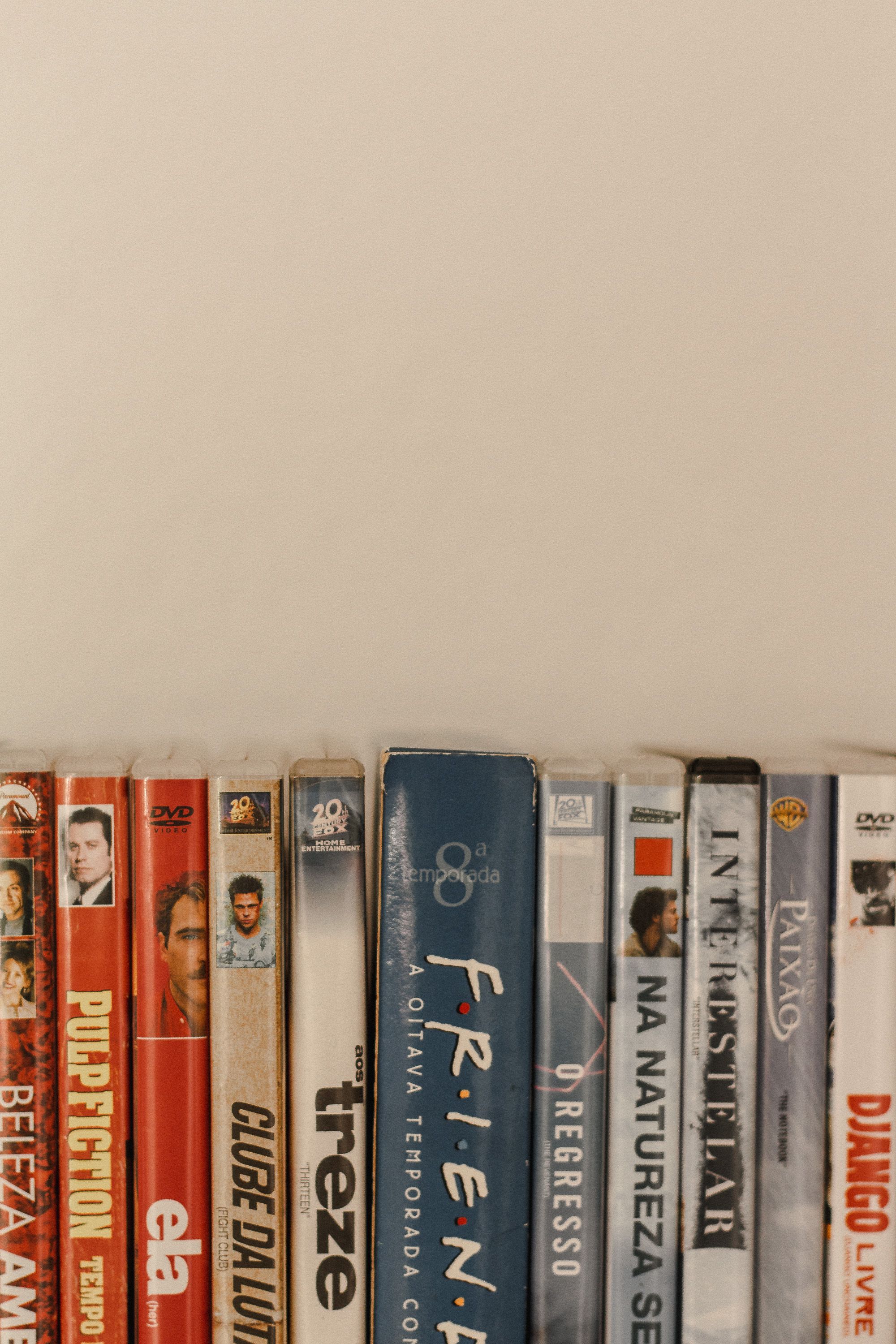 Vertical shot of a DVD collection arranged against a beige background, offering ample copy space.