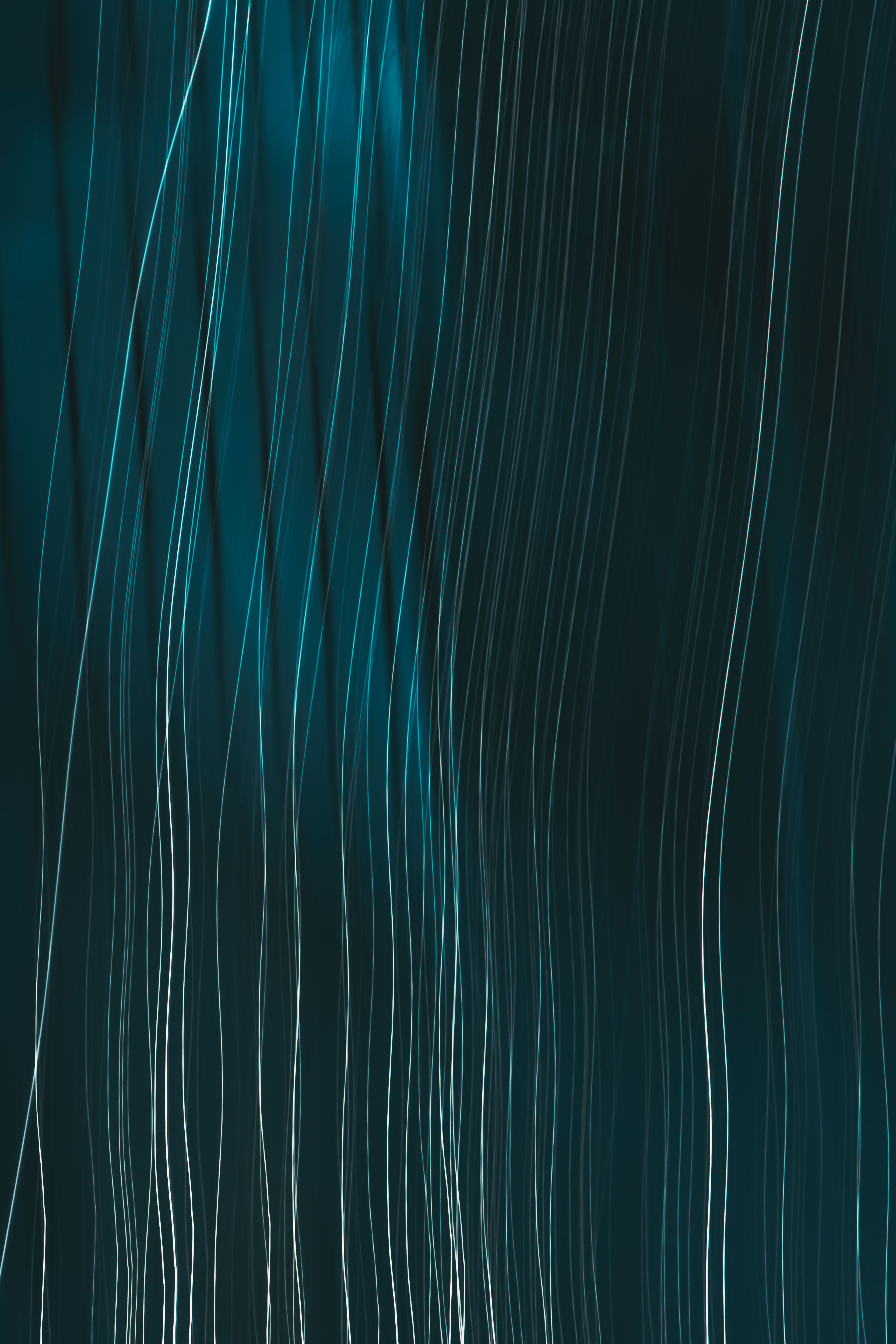 Dynamic abstract lines with teal highlights create a flowing pattern ideal for modern graphic design.