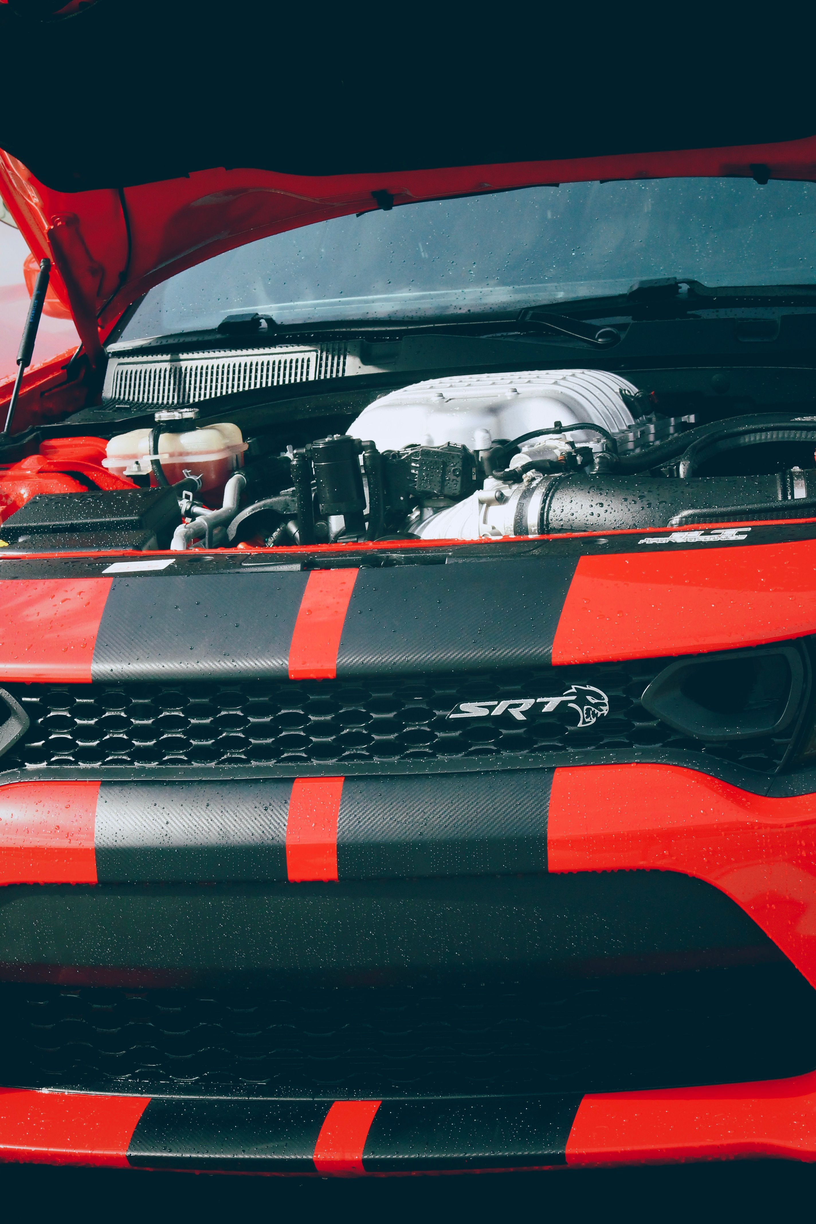 Detailed close-up of a Dodge sports car with open hood showcasing the powerful engine.