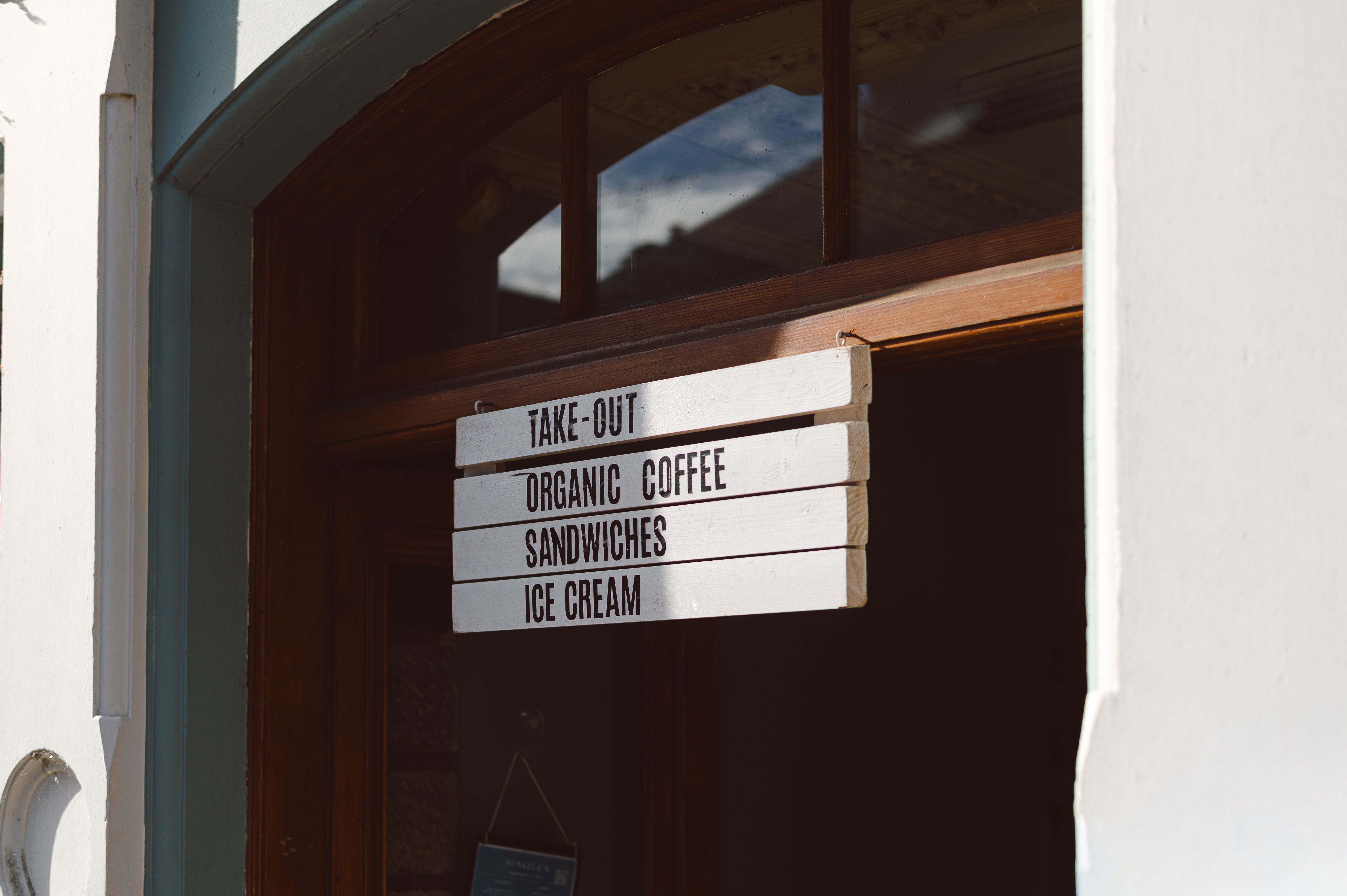 An inviting coffee shop entrance sign with menu options in Dunkeld, Scotland.
