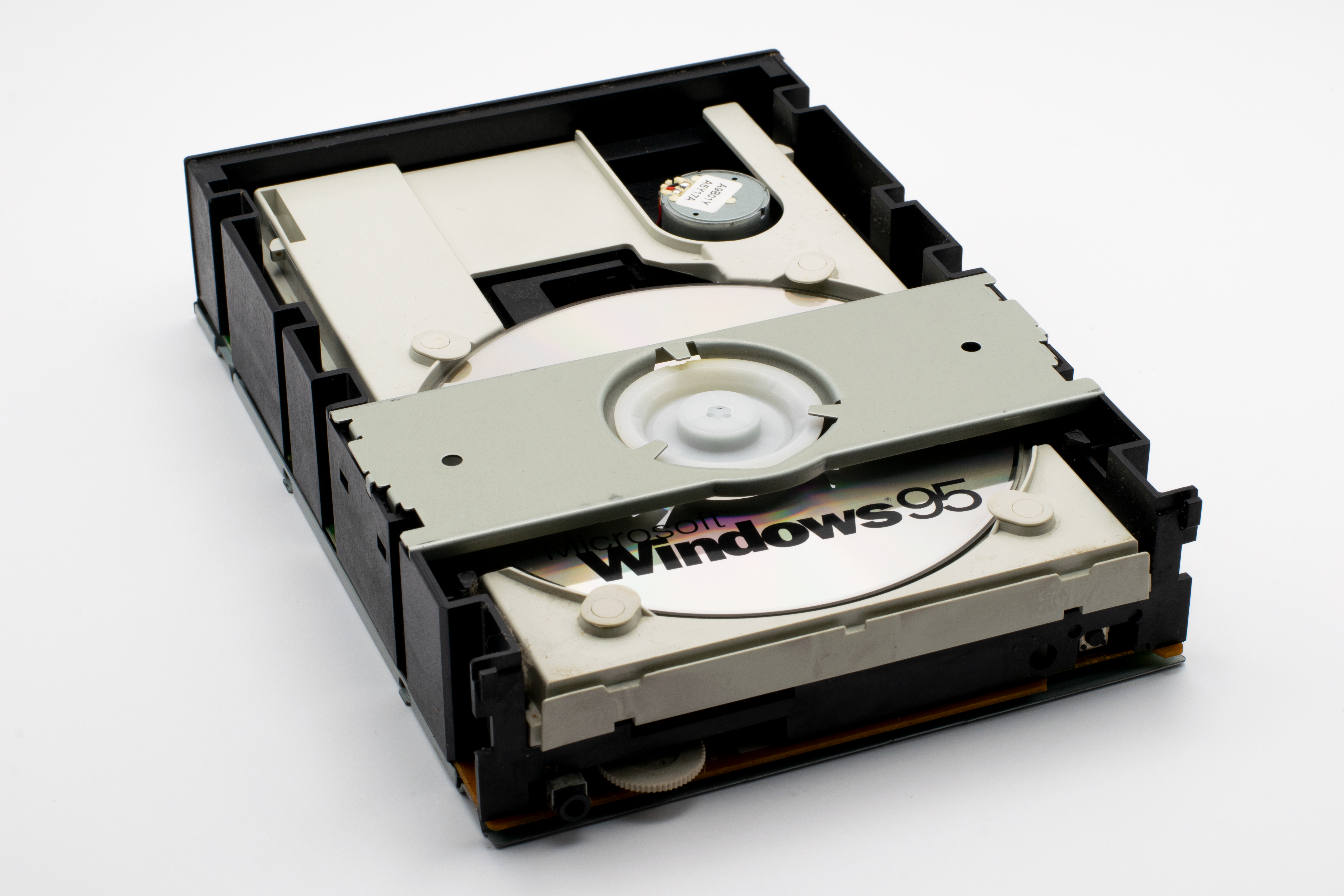 Close-up of a retro CD-ROM drive with a Windows 95 disc, showcasing vintage technology.
