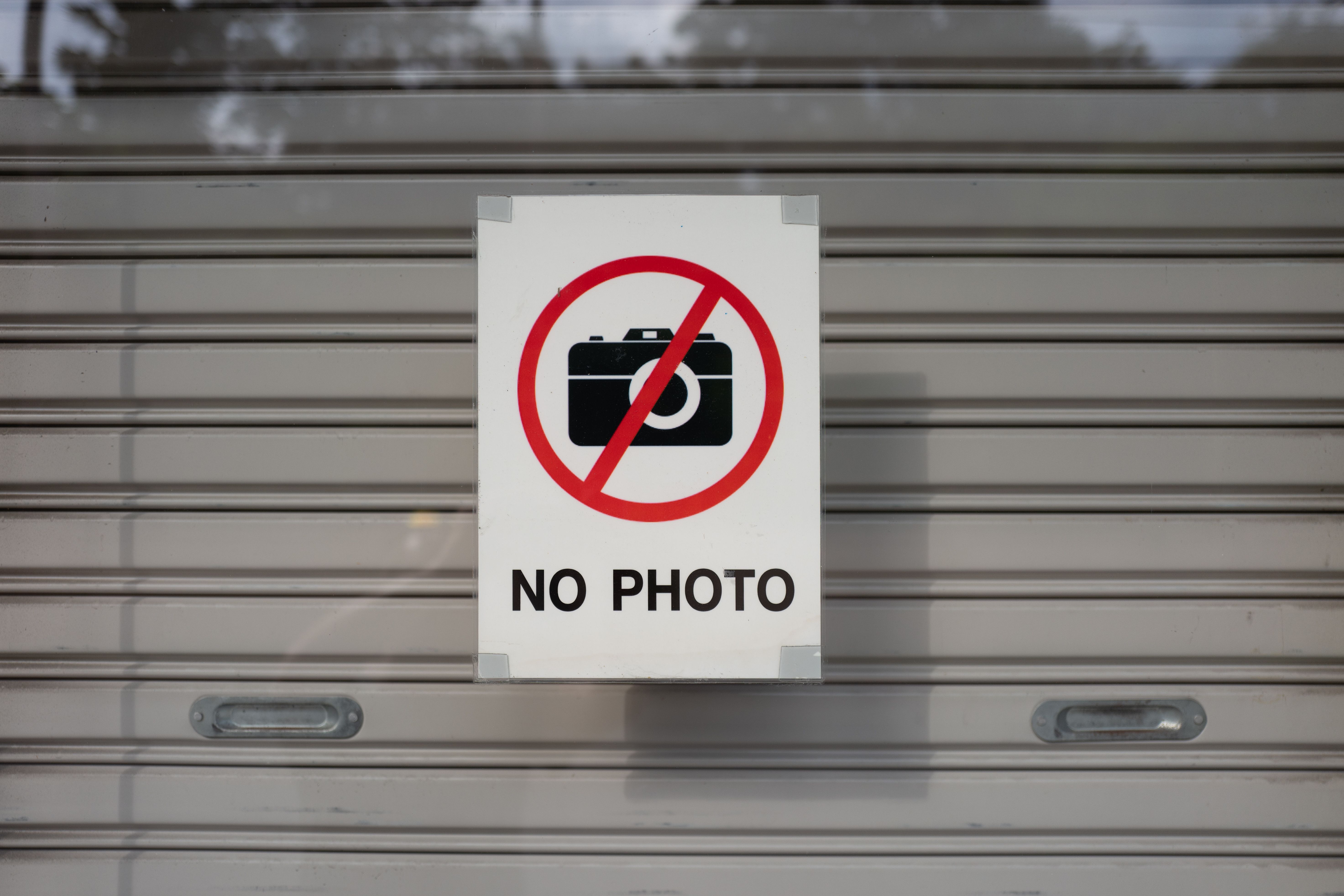 A 'No Photo' sign on a shutter door in Phuket, Thailand.