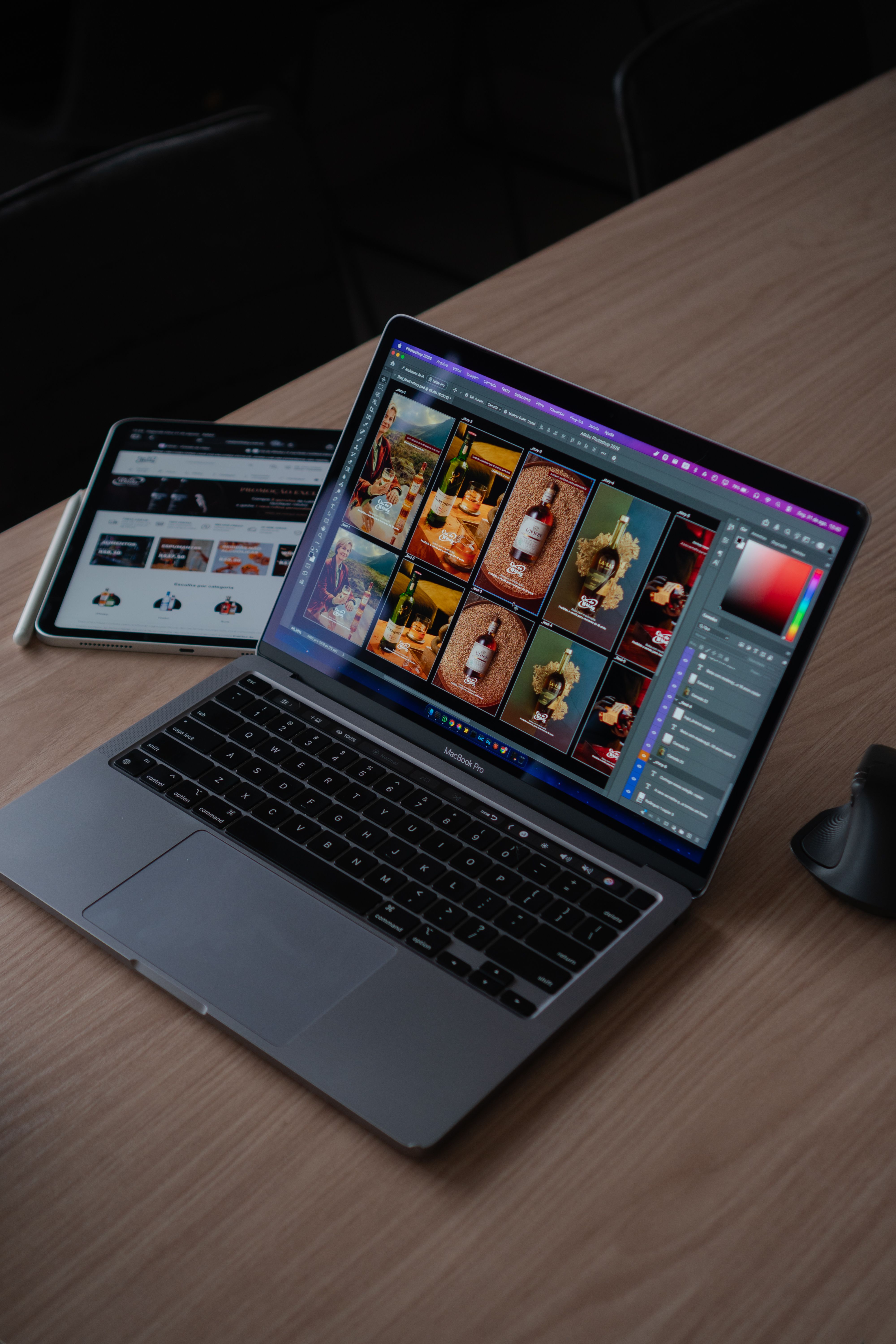 A sleek modern workspace featuring a laptop displaying creative design software alongside a tablet.