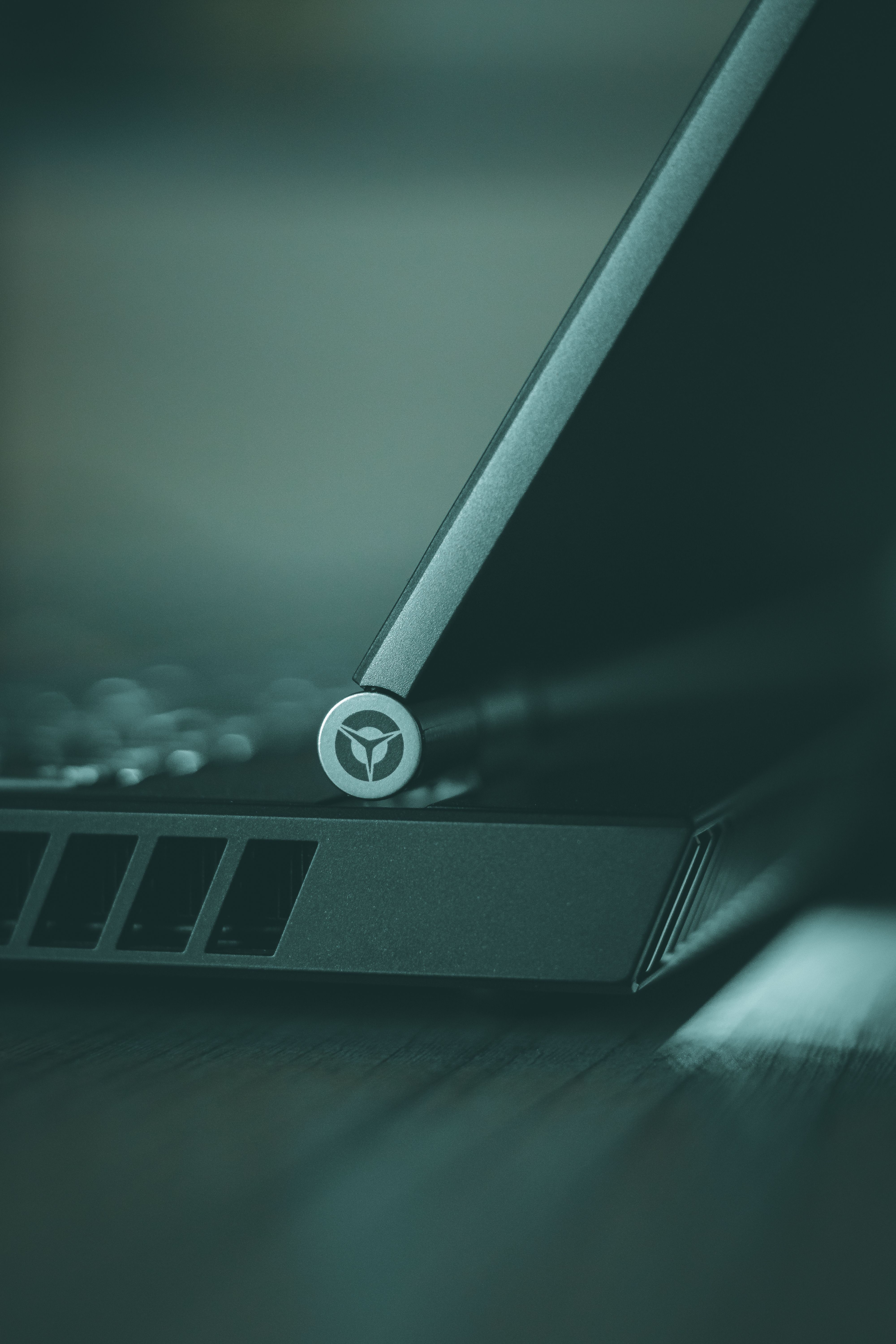 Focused close-up of a laptop hinge showcasing modern design and technology from a vertical angle.